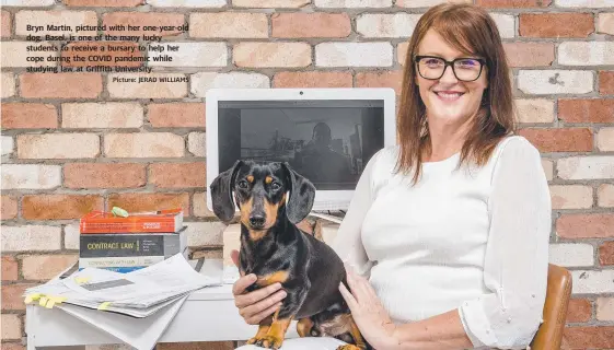  ?? Picture: JERAD WILLIAMS ?? Bryn Martin, pictured with her one-year-old dog, Basel, is one of the many lucky students to receive a bursary to help her cope during the COVID pandemic while studying law at Griffith University.