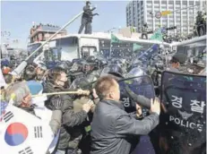  ?? FOTO: REUTERS ?? Manifestan­tes a favor de Park Geun-hye se enfrentan con la policía, ayer en Seúl.