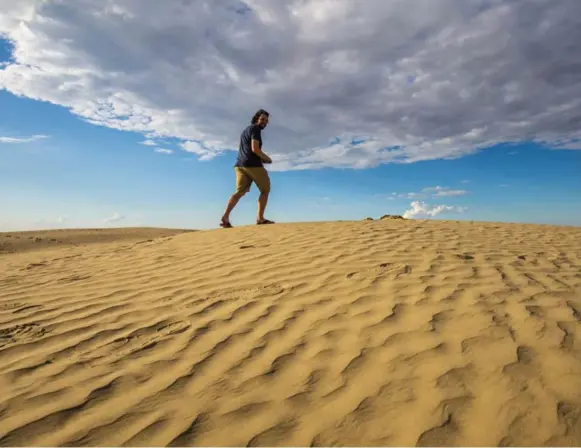  ?? BRENDAN VAN SON ?? A tourist climbs the sand dunes in the Great Sandhills of Saskatchew­an.