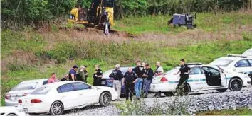  ?? AP ?? Police gather on a road next to constructi­on equipment in a wooded area near where Waffle House shooting suspect Travis Reinking was captured on Monday in Nashville, Tennessee.
