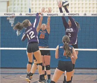  ?? JULIE JOCSAK THE ST. CATHARINES STANDARD ?? Kate Fenwick of A.N. Myer spikes the ball over the net defended by, left, Brenna Ferrara of Centennial and Kathleen Longley of A.N. Myer during the high school volleyball showcase at Niagara College Tuesday.