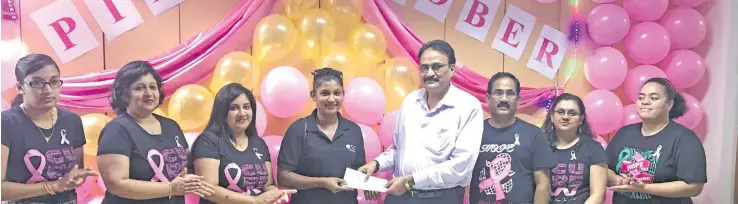  ?? Photo. Bank of Baroda ?? Bank of Baroda chief executive Govindsing Rajput (white shirt) handing over cheque to Fiji Cancer Society staff Shiuwani Devi during their Pinktober morning tea at their head office in Suva on October 27, 2017. .