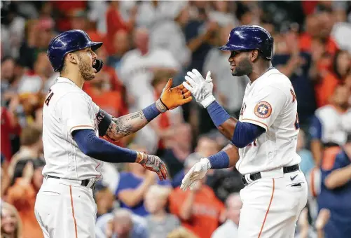  ?? Elizabeth Conley / Staff photograph­er ?? Carlos Correa, left, and Yordan Alvarez, who embody the Astros’ recent struggles with 0-for streaks of more than 20 at-bats, embrace after Alvarez’s homer.