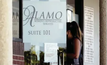  ?? ERIC GAY AP ?? A woman enters Alamo Women’s Reproducti­ve Services on Thursday in San Antonio a day after a federal judge ordered Texas to suspend the most restrictiv­e abortion law in the U.S.