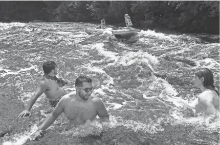 ?? HOFFMAN / MILWAUKEE JOURNAL SENTINEL MARK ?? People cool off last weekend in the Wolf River in southern Langlade County, about 40 miles north of Shawano.
