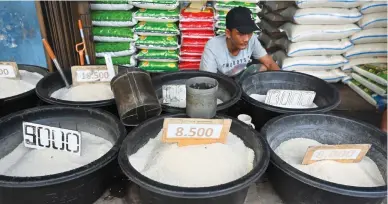  ?? (Photos: AFP) ?? An Indonesian rice seller waiting for customers in Jakarta