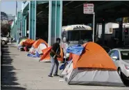  ?? AP FILE PHOTO BY ERIC RISBERG ?? In this 2016 file photo, a man stands outside his tent on Division Street in San Francisco.