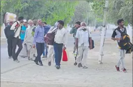  ?? HT PHOTOS ?? Followers leaving the Dera Sacha Sauda headquarte­rs in Sirsa after they were evicted on Tuesday; and (right) police personnel transporti­ng the disciples in the Haryana Roadways buses.