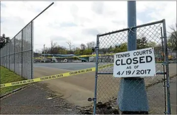  ?? TANIA BARRICKLO —DAILY FREEMAN ?? Yellow caution tape surrounds the tennis courts at Forsyth Park off Lucas Avenue in Kingston, N.Y., which are awaiting renovation.