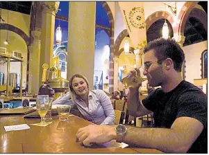  ?? AP/DAKE KANG ?? Jesse Hulien has a beer with Molly Hartman at the bar at Church Brew Works, a Pittsburgh sanctuary renovated into a brewery.