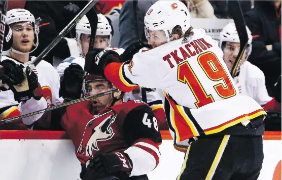  ?? ROSS D. FRANKLIN/THE ASSOCIATED PRESS ?? Flames winger Matthew Tkachuk delivers a blow to the Coyotes’ Jordan Martinook during action on Thursday night in Glendale, Ariz. Tkachuk later scored his 24th goal of the year in a 5-2 Calgary victory to cap their two-game road trip with the players’...