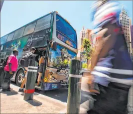  ?? L.E. Baskow Las Vegas Review-journal @Left_eye_images ?? Passengers board an RTC bus north of the MGM Grand on the Strip on Tuesday. The RTC has seen a decline in Strip ridership and revenue.