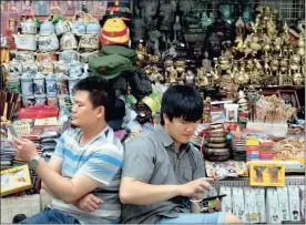  ?? PHOTO: AP ?? Vendors wait for customers in the Wangfujing shopping district in Beijing. Manufactur­ing in China shrank for the third consecutiv­e month in May.