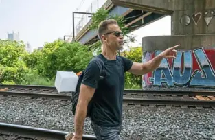  ?? Andrew Rush/Post-Gazette ?? Erik Wiesemann, who runs Light in My City, walks on South Side to deliver supplies to a homeless camp under a bridge last year.