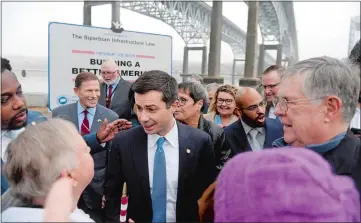  ?? SARAH GORDON/THE DAY ?? U.S. Transporta­tion Secretary Pete Buttigieg speaks with attendees following a press conference at the Thames River Boat Launch in New London on Jan. 4. The Gold Star Memorial Bridge repair project was awarded $158 million in federal grants to accelerate repairs as part of President Joe Biden’s Bipartisan Infrastruc­ture Law.