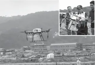  ?? Photo by Herman Danis/DA-CAR Regional Agricultur­e and Fisheries Section ?? Agricultur­e Secretary Emmanuel Piñol leads the actual drone spraying test in a strawberry farm in La Trinidad, Benguet. A hectare of farmland can be sprayed with a liter of fertilizer in 10 minutes, at P1,500.