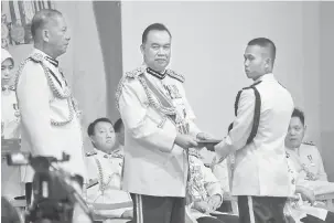  ??  ?? TAHNIAH: Dzuraidi (tengah) menyampaik­an sijil kepada pelatih yang berjaya menamatkan latihan asas kepolisan sambil disaksikan Azman (kiri).