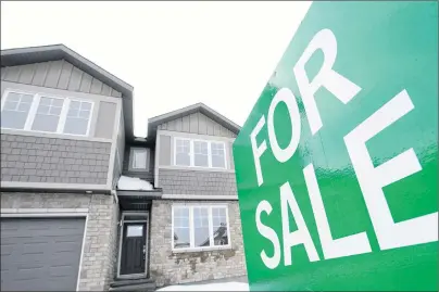  ?? CP PHOTO ?? A for sale sign is shown in by new homes in Beckwith, Ont., just outside Ottawa, in January, 2018. The number of Canadian homes sold in March plunged 22.7 per cent from the same month last year. The national average price was around $491,000, down 10.4...