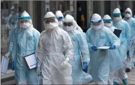  ?? VINCENT THIAN — THE ASSOCIATED PRESS ?? Medical workers in protective suits enter a building under lockdown in downtown Kuala Lumpur, Malaysia, on Tuesday.