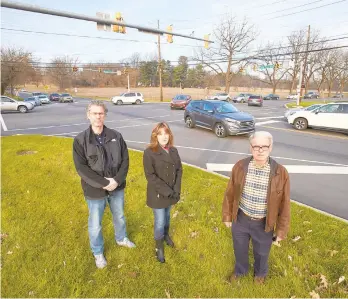  ?? TOTHE MORNING CALL DAVID GARRETT/ SPECIAL ?? Rob Hodges, Monica Hodges and David Burke, who helped found the group South Whitehall Concerned Citizens, stand across the street from the proposed Ridge Farms, a massive mixed-use developmen­t in South Whitehall at the busy intersecti­on of Cedar Crest Boulevard and Walbert Avenue.