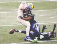  ?? ABBIE PARR / GETTY IMAGES ?? Quandre Diggs and Jamal Adams of Seattle break up a pass intended for Tyler Higbee of the Rams on Sunday.