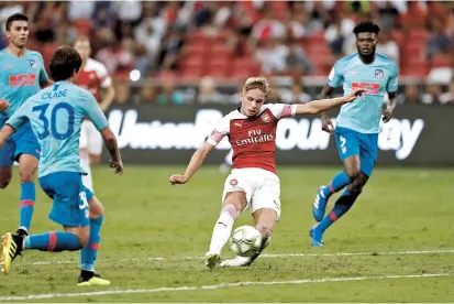  ??  ?? Arsenal’s Emile Smith-Rowe scores the equalizer for the English Premier League team during their Internatio­nal Champions Cup match against Atletico Madrid in Singapore last night. The match finished 1-1 in regulation, with the Spanish La Liga outfit...