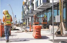  ?? Brittany Hosea-Small / Special to The Chronicle ?? Constructi­on crews work on the Aero apartment building at Alameda Point. A ferry terminal is planned for a block away.