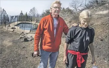  ?? Brian van der Brug Los Angeles Times ?? JOHN AND JAN PASCOE survived the wildfire that ravaged Santa Rosa early Monday by spending six harrowing hours in their neighbors’ pool, in the background. “We were in survival mode,” Jan said.