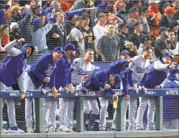  ?? Robert Gauthier Los Angeles Times ?? THE DODGERS’ dugout cheers after Cody Bellinger’s go-ahead single during the ninth inning in Game 5 on Thursday night. The Dodgers won the game 2-1 and advanced to the National League Championsh­ip Series.