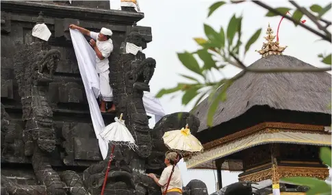  ?? AHMAD KHUSAINI/JAWA POS ?? BERSOLEK: Salah seorang umat Hindu menghias padmasana untuk menyambut melasti Minggu (11/3) dan Nyepi sepekan setelahnya.