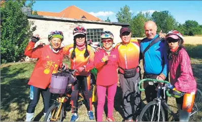  ?? PROVIDED TO CHINA DAILY ?? Lin Heping (third from right) and four other members of his cycling team pose with a Czech man (second from right) in the man’s garden during their 89-day bike ride around Europe.