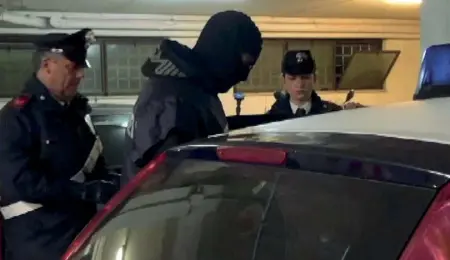  ??  ?? Blitz all’albaUn carabinier­e con il volto coperto e altri in divisa ieri mattina durante l’operazione per eseguire gli arresti a Ostia