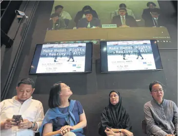 ?? PATIPAT JANTHONG ?? Human rights activists and National Human Rights Commission Angkhana Neelapaiji­t, second right, follow a broadcast of the second Universal Periodic Review from Geneva at a restaurant in the Ploenchit area yesterday.