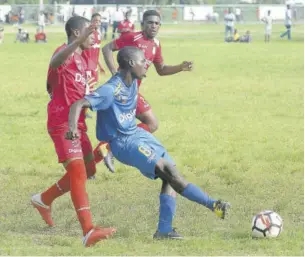  ?? (Photo: Joseph Wellington) ?? Donald Walters (right) of Dehnam Town plays the ball ahead of Kevon Gordon (left), of Bridgeport High, during their Issa/digicel Manning Cup Group D match at Tivoli High School ground yesterday. Denham Town won 1-0.