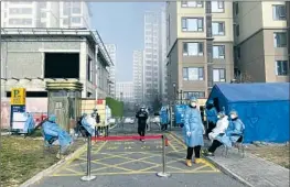  ?? HEALTH Bloomberg ?? workers guard the front of a Beijing residentia­l compound in November. COVID restrictio­ns and lockdowns exacerbate­d China’s economic slowdown.