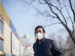  ??  ?? BEIJING: A man wearing a face mask stands in front of a mall. — AFP