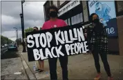  ?? JIM MONE — THE ASSOCIATED PRESS ?? Protesters on Tuesday gather near the site where a man died in police custody Monday night in Minneapoli­s. The incident was videotaped by a bystander.