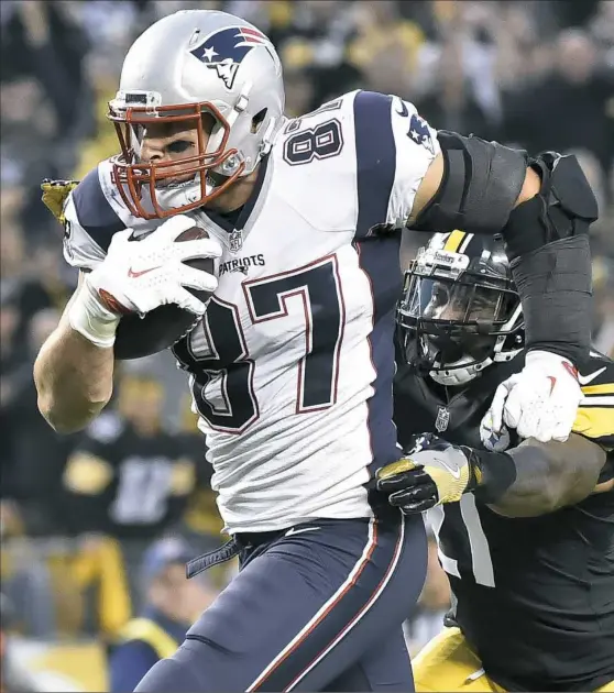  ?? Matt Freed/Post-Gazette ?? New England Patriots tight end Rob Gronkowski carries for a touchdown in front of Steelers safety Robert Golden in the third quarter Sunday at Heinz Field.
