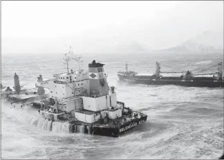  ?? U.S COAST GUARD VIA THE NEW YORK TIMES ?? The 738-foot Malaysian cargo ship Selendang Ayu, split in two in high seas and gale-force winds, sits Dec. 11, 2004, offshore of Skan Bay on Unalaska Island near Unalaska, Alaska. Six crew members died when a rescue helicopter that had picked them up...