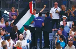  ?? (Issei Kato/Reuters) ?? SECURITY PERSONNEL eject from the stands a fan displaying a flag in support of Palestine during the women’s final match at the Australian Open tennis tournament in Melbourne, in January.