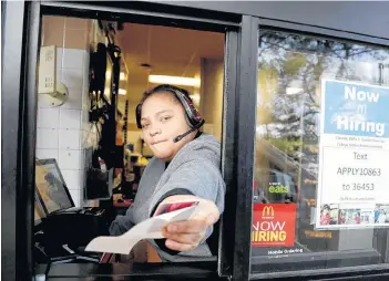  ?? AP PHOTO ?? A cashier returns a credit card and a receipt at a McDonald’s window, where signage for job openings is displayed, in Atlantic Highlands, N.J., earlier this year.