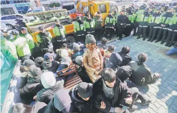  ??  ?? South Korean activists staging a sit- in protest around a statue ( centre) of a teenage girl symbolizin­g former ‘comfort women’ who served as sex slaves for Japanese soldiers during World War II, which they tried to set up outside the Japanese...