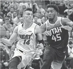  ?? RICK BOWMER/AP ?? Utah Jazz guard Donovan Mitchell (45) defends against Miami Heat guard Tyler Herro (14) during the first half of Saturday’s game in Salt Lake City. Herro scored 27 points to lead the Heat to a 11-105 win.