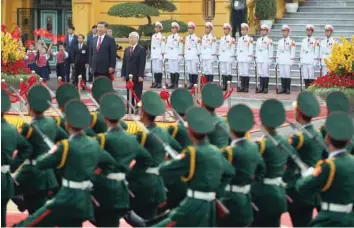  ?? — Reuters ?? China’s President Xi Jinping and Vietnam’s Communist Party General Secretary Nguyen Phu Trong review an honour guard during a welcoming ceremony at the presidenti­al palace in Hanoi on Sunday.