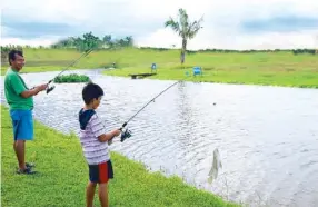  ??  ?? Father and son having fun fishing at South Lake Village