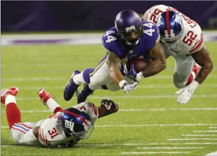  ?? JIM MONE — THE ASSOCIATED PRESS ?? Minnesota Vikings running back Matt Asiata (44) dives for extra yardage between New York Giants defenders Trevin Wade, left, and Jonathan Casillas (52) during the second half of an NFL football game, Monday in Minneapoli­s.
