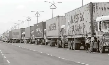  ?? Rajanish Kakade / Associated Press ?? Drivers of trucks carrying containers wait outside a terminal in Mumbai, India. A cyberattac­k earlier this week has stalled operations at India’s busiest container port.