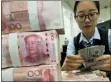  ?? CHINATOPIX VIA AP ?? A bank employee counts U.S. dollar banknotes next to stack of 100 Chinese yuan notes at a bank outlet in Hai’an in eastern China’s Jiangsu province, Tuesday. China’s yuan fell further Tuesday against the U.S. dollar, fueling fears about increasing global damage from Beijing’s trade war with President Donald Trump.