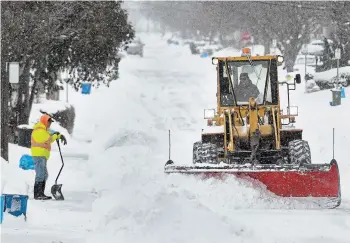  ?? PHOTOS BY BARRY GRAY THE HAMILTON SPECTATOR ?? A west Mountain man takes a break from shovelling to watch as a snowplow heads down his street. Many Hamiltonia­ns spent part of Tuesday digging out after another large snowfall overnight Monday.