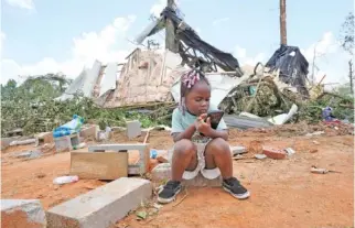  ?? AP PHOTO/ROGELIO V. SOLIS ?? On Monday, Genesis Jackson, 3, sits in front of a relative’s home following a Sunday night tornado that swept through the small community of Louin, Miss.